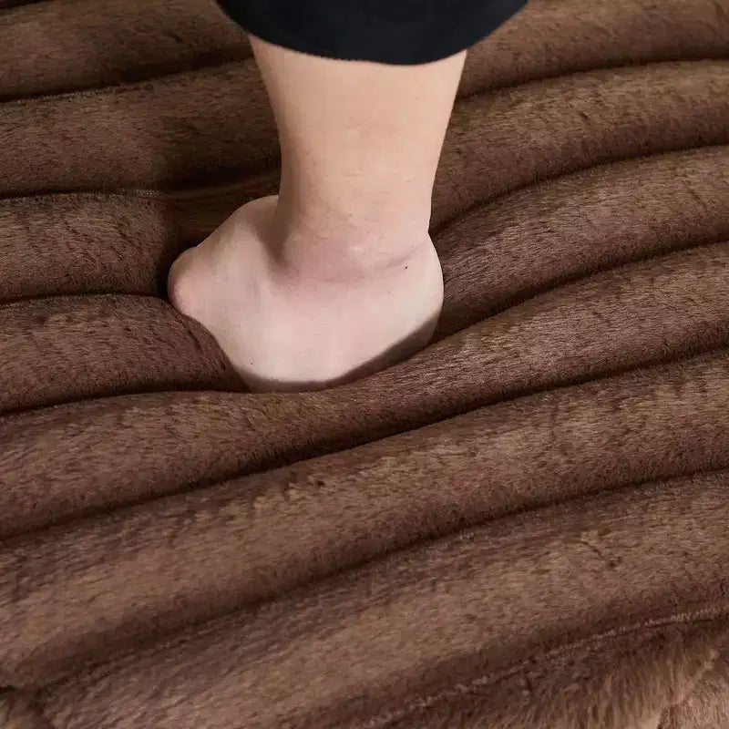 Repose-pieds moelleux et volumineux avec pieds en métal et fausse fourrure.
