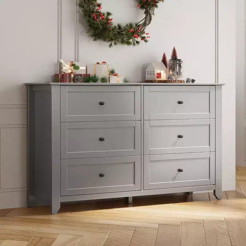 Commode à six tiroirs pour la chambre, avec de larges tiroirs en bois munis de poignées métalliques.