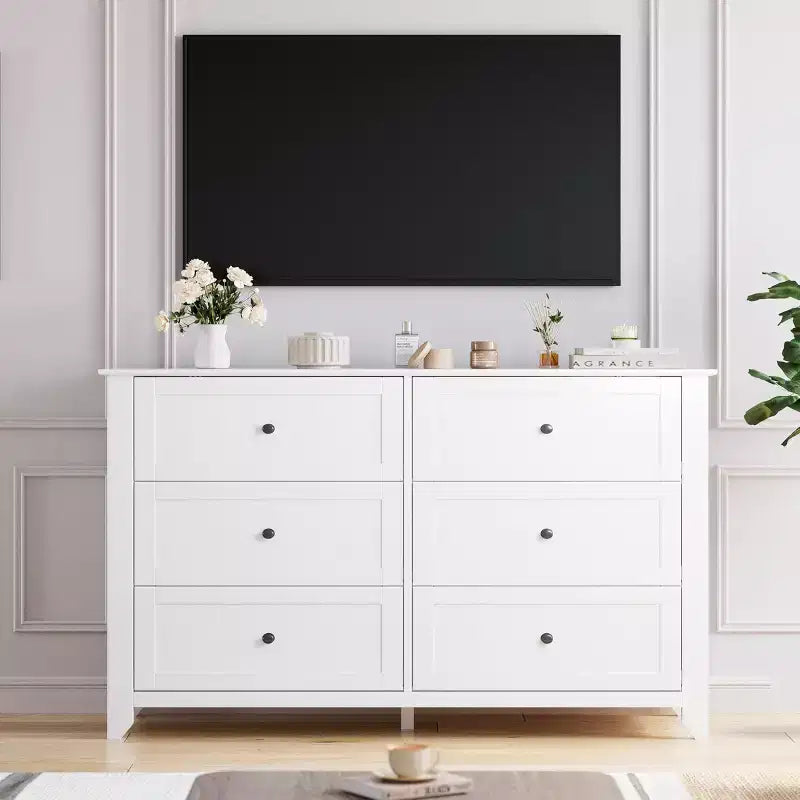 Commode à six tiroirs pour la chambre, avec de larges tiroirs en bois munis de poignées métalliques.