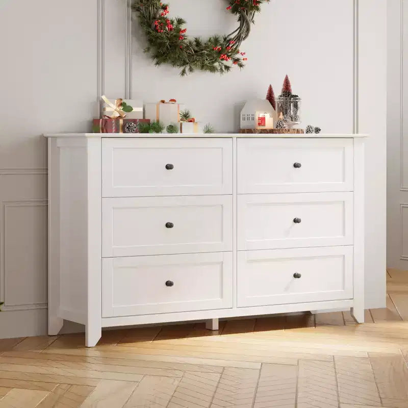 Commode à six tiroirs pour la chambre, avec de larges tiroirs en bois munis de poignées métalliques.