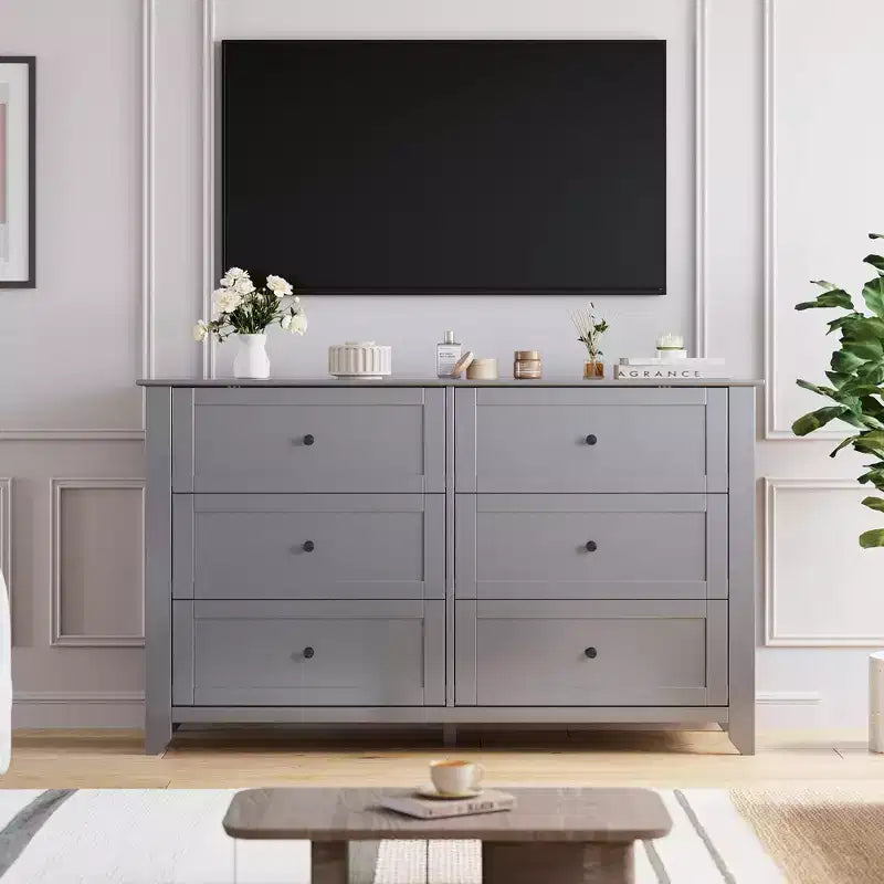 Commode à six tiroirs pour la chambre, avec de larges tiroirs en bois munis de poignées métalliques.