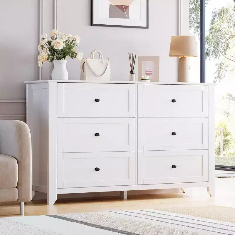 Commode à six tiroirs pour la chambre, avec de larges tiroirs en bois munis de poignées métalliques.